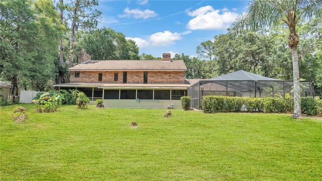 418 N Rd, Lakeland, FL 33809 - rear view of house featuring a chimney and glass enclosure