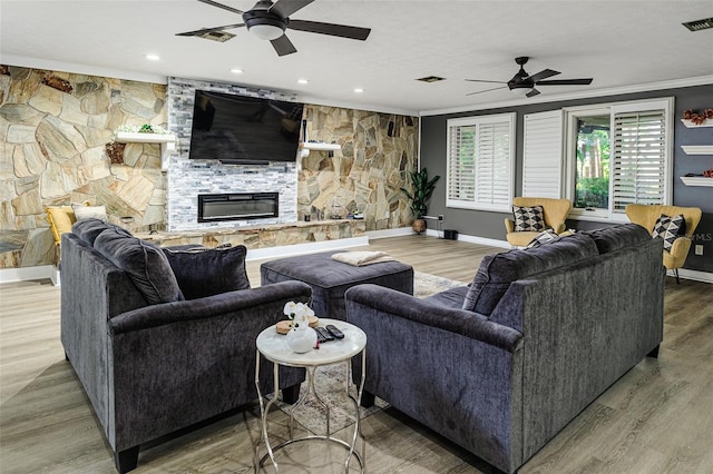 418 N Rd, Lakeland, FL 33809 - living room with a ceiling fan, a stone fireplace, crown molding, baseboards, and wood finished floors