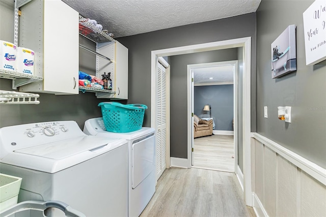 418 N Rd, Lakeland, FL 33809 - laundry room with washer and dryer, cabinet space, light wood finished floors, and baseboards