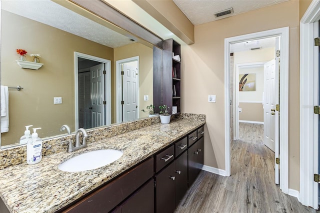 418 N Rd, Lakeland, FL 33809 - bathroom featuring wood finished floors, vanity, baseboards, and a textured ceiling