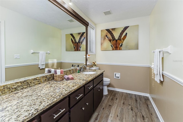 418 N Rd, Lakeland, FL 33809 - bathroom with wood finished floors, toilet, vanity, and baseboards