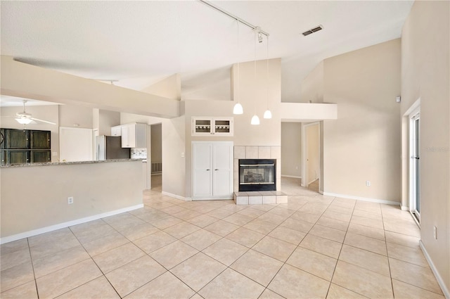 630 Heather Glen Loop, Winter Haven, FL 33884 - unfurnished living room with track lighting, light tile patterned floors, ceiling fan, a tiled fireplace, and high vaulted ceiling