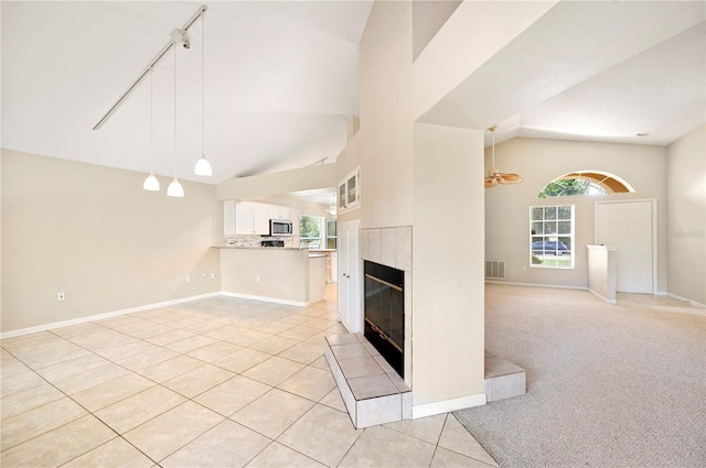 630 Heather Glen Loop, Winter Haven, FL 33884 - unfurnished living room featuring a tile fireplace, healthy amount of natural light, light tile patterned flooring, baseboards, and a high ceiling