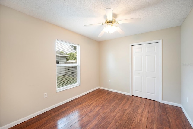 630 Heather Glen Loop, Winter Haven, FL 33884 - unfurnished bedroom featuring wood finished floors, baseboards, a closet, a ceiling fan, and a textured ceiling