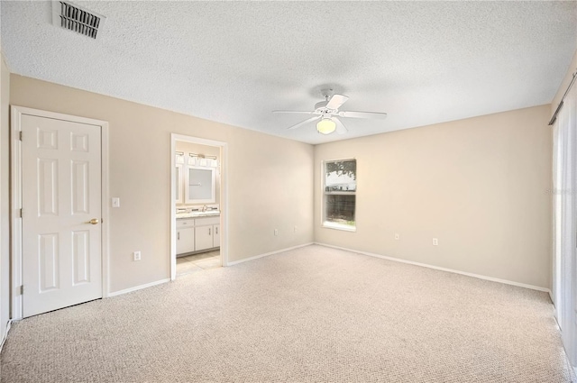 630 Heather Glen Loop, Winter Haven, FL 33884 - unfurnished bedroom featuring light colored carpet, a textured ceiling, a sink, baseboards, and ensuite bathroom