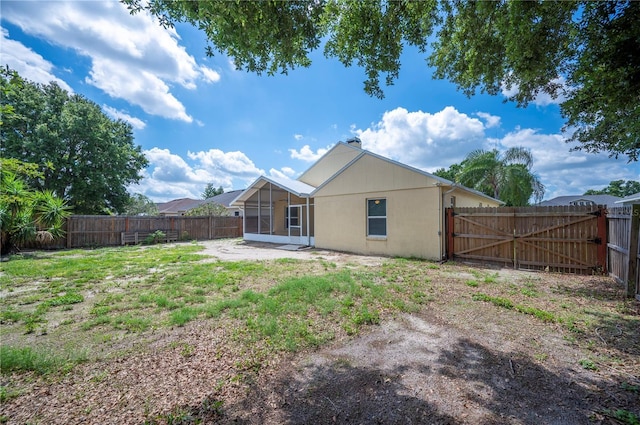 630 Heather Glen Loop, Winter Haven, FL 33884 - rear view of property with a sunroom, a fenced backyard, a gate, and a chimney
