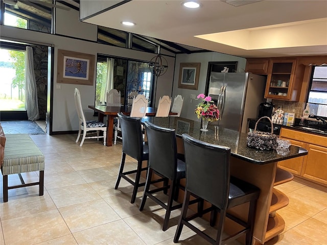 9402 Cat Track Trl, Lake Wales, FL 33898 - kitchen with stainless steel refrigerator with ice dispenser, a kitchen bar, glass insert cabinets, a center island, and plenty of natural light