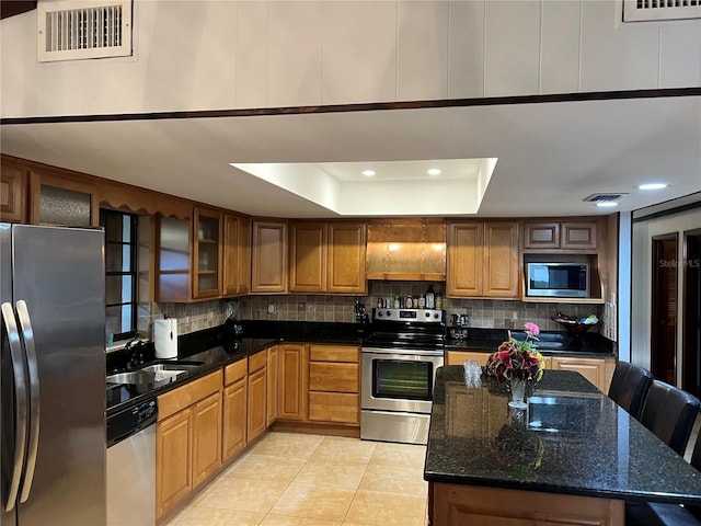 9402 Cat Track Trl, Lake Wales, FL 33898 - kitchen with appliances with stainless steel finishes, a tray ceiling, decorative backsplash, light tile patterned flooring, and recessed lighting