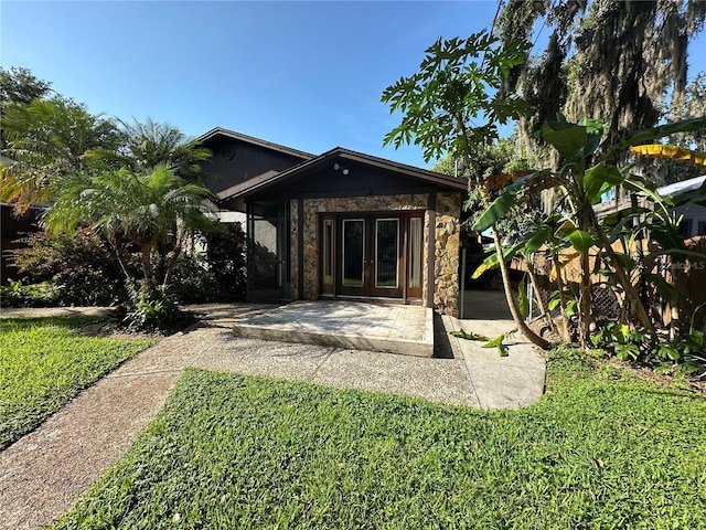 9402 Cat Track Trl, Lake Wales, FL 33898 - back of property with stone siding, french doors, and a lawn