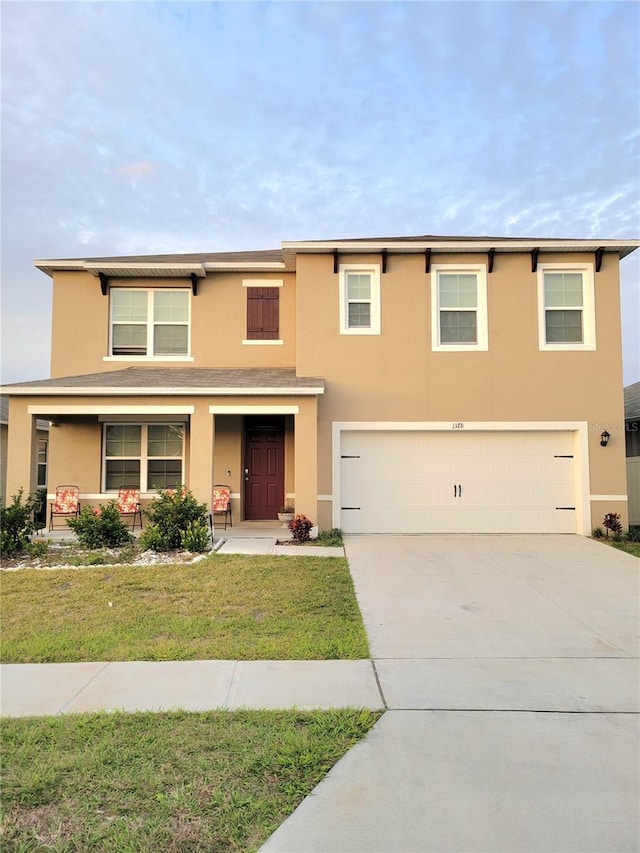 1378 Fox Squirrel Dr, Davenport, FL 33897 - view of front of home with stucco siding, a garage, concrete driveway, and a front yard
