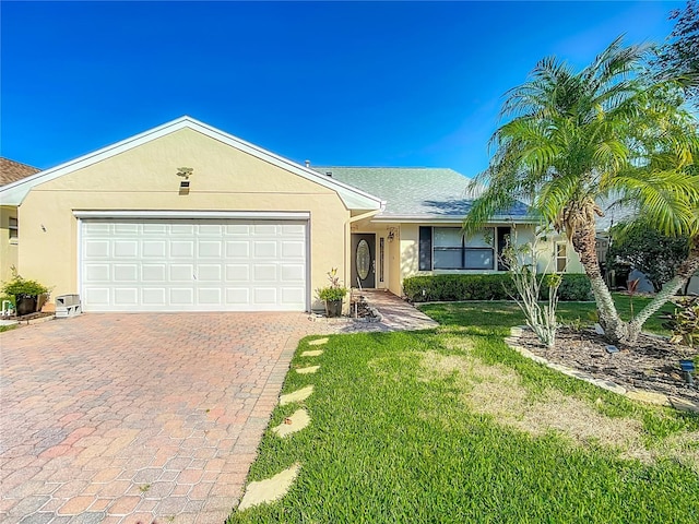 560 Saint Andrews Rd, Winter Haven, FL 33884 - ranch-style house featuring decorative driveway, a garage, a front lawn, and stucco siding