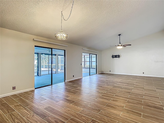 560 Saint Andrews Rd, Winter Haven, FL 33884 - unfurnished room featuring a textured ceiling, a chandelier, a ceiling fan, wood finished floors, and baseboards