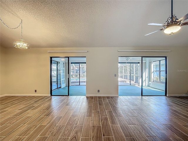 560 Saint Andrews Rd, Winter Haven, FL 33884 - unfurnished room featuring dark wood-type flooring, a textured ceiling, healthy amount of natural light, and baseboards