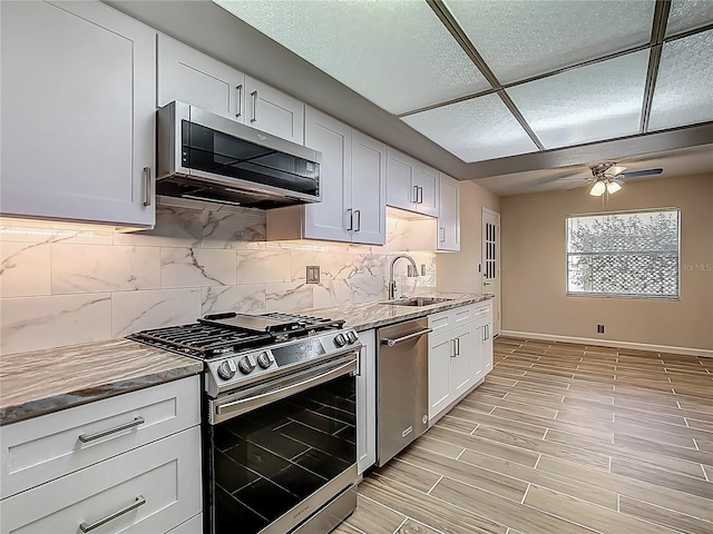 560 Saint Andrews Rd, Winter Haven, FL 33884 - kitchen featuring appliances with stainless steel finishes, a sink, a ceiling fan, backsplash, and baseboards