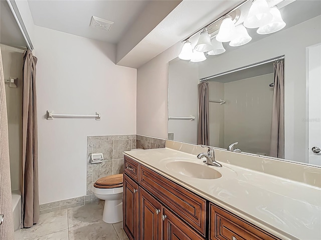 560 Saint Andrews Rd, Winter Haven, FL 33884 - full bathroom with toilet, vanity, tile walls, and tile patterned floors