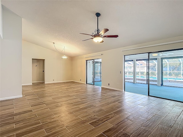 560 Saint Andrews Rd, Winter Haven, FL 33884 - spare room with lofted ceiling, a ceiling fan, wood finish floors, baseboards, and a textured ceiling
