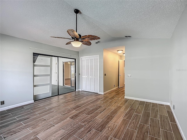 560 Saint Andrews Rd, Winter Haven, FL 33884 - unfurnished bedroom with dark wood-style floors, baseboards, a textured ceiling, lofted ceiling, and ceiling fan