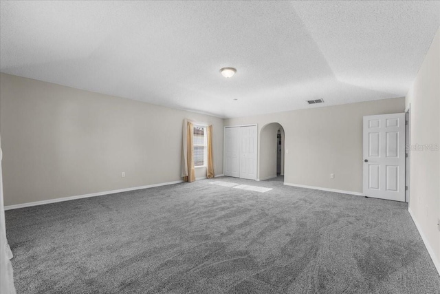 1800 Emily Dr, Winter Haven, FL 33884 - empty room featuring arched walkways, carpet, a textured ceiling, and baseboards