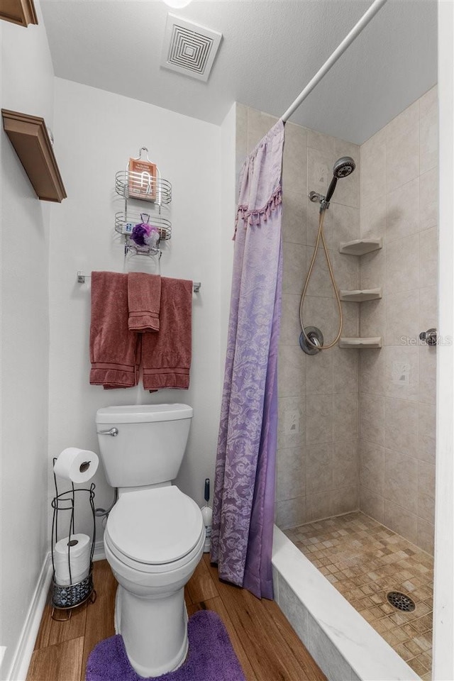 1800 Emily Dr, Winter Haven, FL 33884 - full bath featuring wood finished floors, a stall shower, and toilet