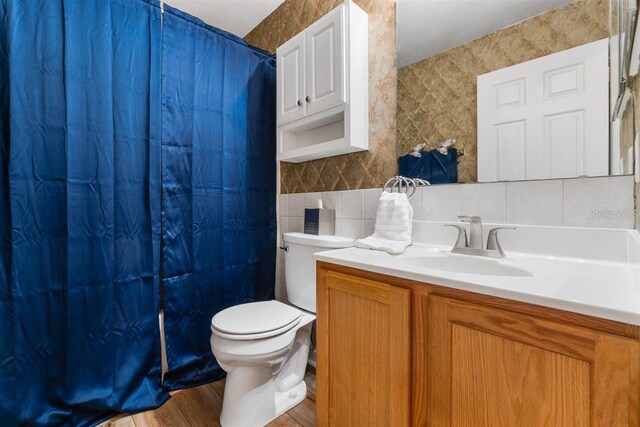 1800 Emily Dr, Winter Haven, FL 33884 - full bath featuring tile walls, toilet, backsplash, vanity, and wood finished floors