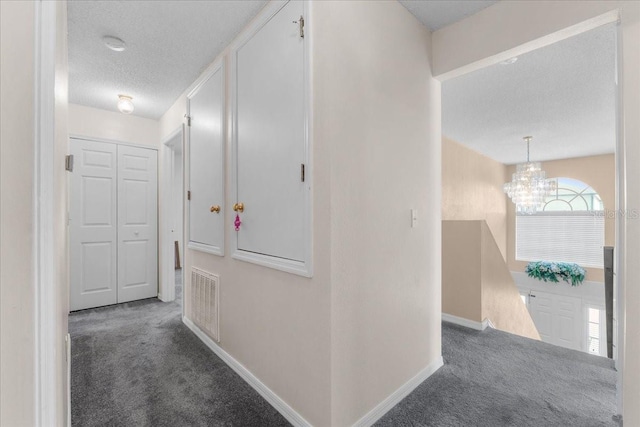1800 Emily Dr, Winter Haven, FL 33884 - hallway featuring carpet floors, a chandelier, baseboards, a textured ceiling, and an upstairs landing