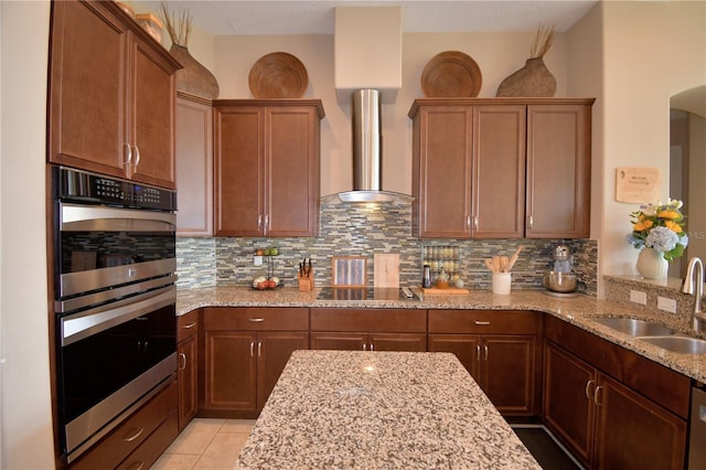 2340 Pinehurst Ct, Davenport, FL 33837 - kitchen with double oven, backsplash, black electric stovetop, and light stone countertops