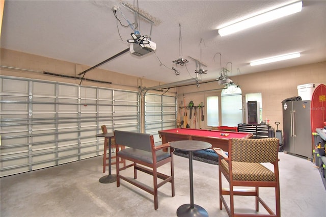 2340 Pinehurst Ct, Davenport, FL 33837 - garage featuring high end refrigerator, a garage door opener, electric panel, and concrete block wall