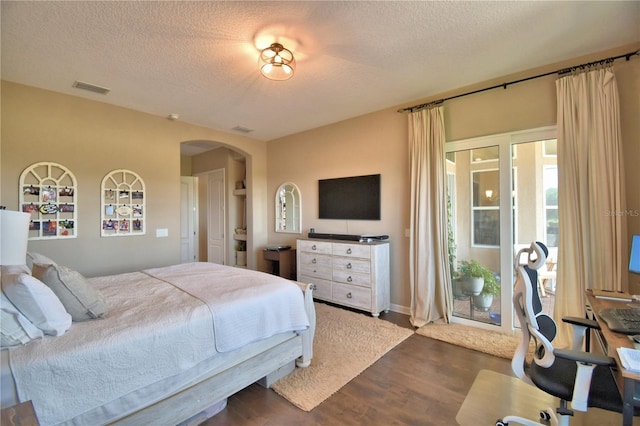 2340 Pinehurst Ct, Davenport, FL 33837 - bedroom with arched walkways, a textured ceiling, dark wood-style flooring, and access to exterior