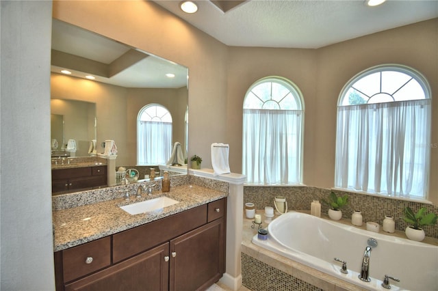 2340 Pinehurst Ct, Davenport, FL 33837 - bathroom featuring healthy amount of natural light, a garden tub, vanity, and recessed lighting