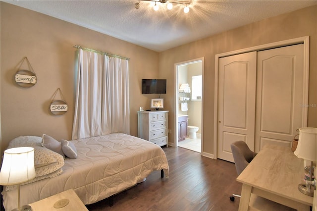 2340 Pinehurst Ct, Davenport, FL 33837 - bedroom with dark wood finished floors, ensuite bathroom, a textured ceiling, and a closet