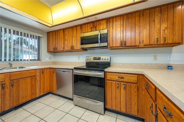 5102 Village Ct Unit E-2, Lake Wales, FL 33898 - kitchen featuring appliances with stainless steel finishes, a sink, brown cabinetry, light countertops, and light tile patterned floors