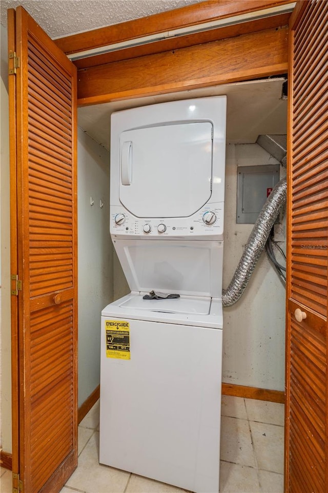 5102 Village Ct Unit E-2, Lake Wales, FL 33898 - laundry room with stacked washer / drying machine, baseboards, and light tile patterned flooring