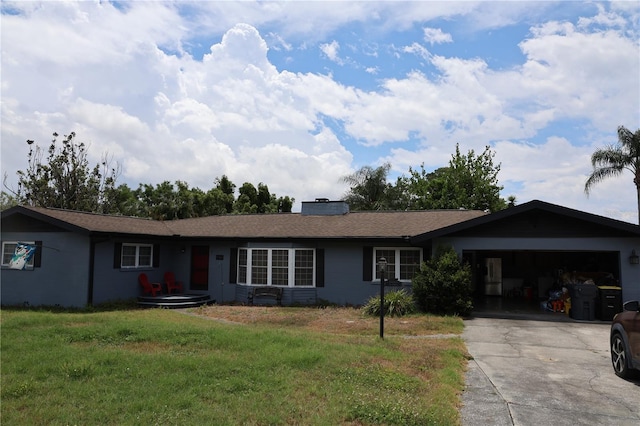 ranch-style home with driveway, an attached garage, a front yard, and a chimney
