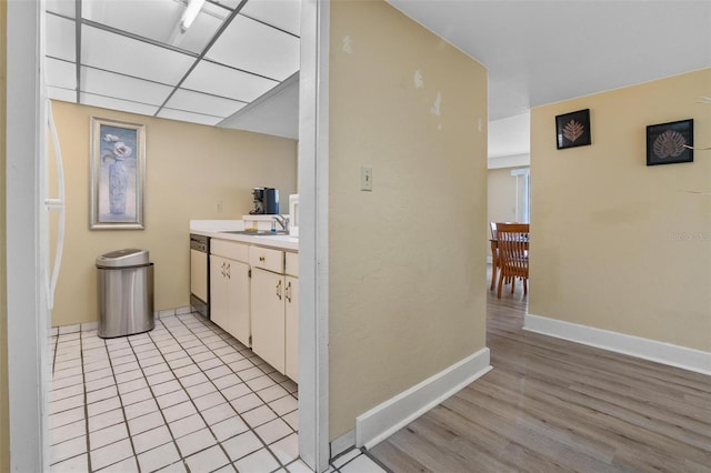 713 Olde Camelot Cir Unit 3303-4, Haines City, FL 33844 - bar with light wood-style floors, baseboards, dishwashing machine, and a sink