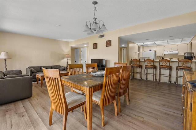 713 Olde Camelot Cir Unit 3303-4, Haines City, FL 33844 - dining space with light wood finished floors and a chandelier