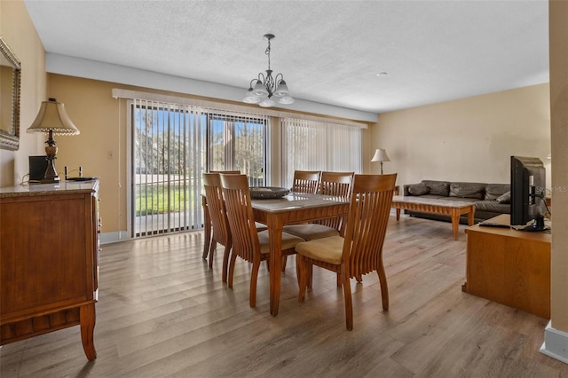 713 Olde Camelot Cir Unit 3303-4, Haines City, FL 33844 - dining area featuring wood finished floors, a chandelier, and a textured ceiling