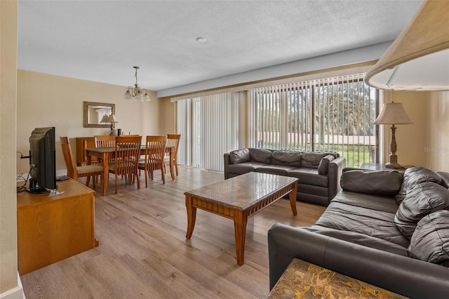 713 Olde Camelot Cir Unit 3303-4, Haines City, FL 33844 - living room with a chandelier, light wood-style floors, and a textured ceiling