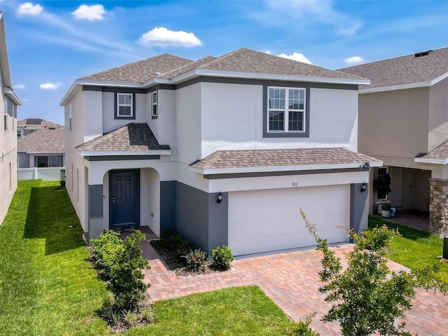 912 Scrub Oak Hammock Rd, Davenport, FL 33837 - traditional-style house with an attached garage, stucco siding, decorative driveway, roof with shingles, and a front lawn