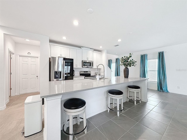 912 Scrub Oak Hammock Rd, Davenport, FL 33837 - kitchen with stainless steel appliances, a sink, white cabinets, a kitchen bar, and recessed lighting