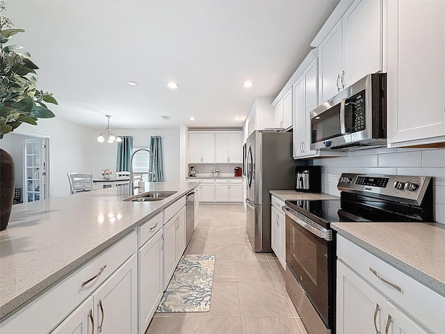 912 Scrub Oak Hammock Rd, Davenport, FL 33837 - kitchen featuring appliances with stainless steel finishes, a sink, white cabinets, tasteful backsplash, and recessed lighting