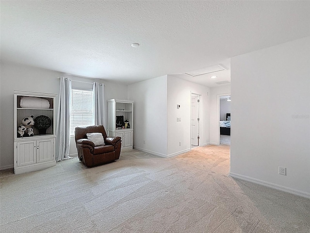 912 Scrub Oak Hammock Rd, Davenport, FL 33837 - living area with light colored carpet, a textured ceiling, baseboards, and attic access