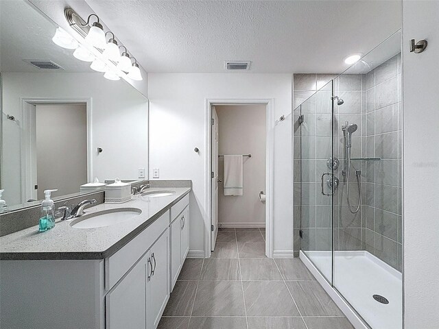 912 Scrub Oak Hammock Rd, Davenport, FL 33837 - full bathroom featuring a shower stall, double vanity, a textured ceiling, baseboards, and tile patterned floors