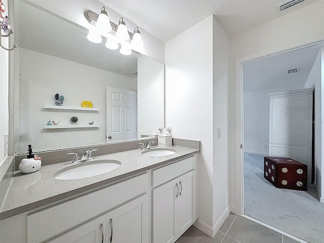 912 Scrub Oak Hammock Rd, Davenport, FL 33837 - bathroom featuring tile patterned flooring, double vanity, baseboards, and a textured ceiling