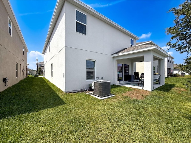 912 Scrub Oak Hammock Rd, Davenport, FL 33837 - back of property featuring central AC, a patio area, stucco siding, and a lawn