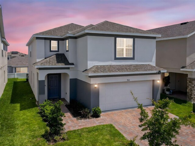 912 Scrub Oak Hammock Rd, Davenport, FL 33837 - traditional-style house with an attached garage, stucco siding, driveway, and a front lawn