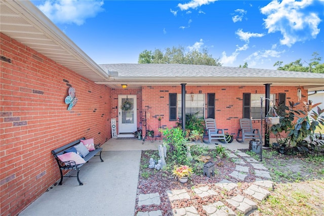 40 Westridge Rd, Davenport, FL 33837 - entrance to property with brick siding, a porch, and roof with shingles