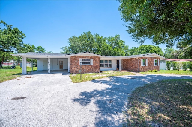 961 Oleander Dr SE, Winter Haven, FL 33880 - ranch-style house with driveway, a front lawn, an attached carport, and brick siding