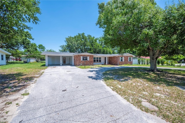 961 Oleander Dr SE, Winter Haven, FL 33880 - ranch-style home with driveway, a front yard, brick siding, and a carport