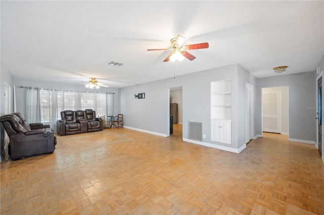 961 Oleander Dr SE, Winter Haven, FL 33880 - living area with a ceiling fan, baseboards, and built in shelves