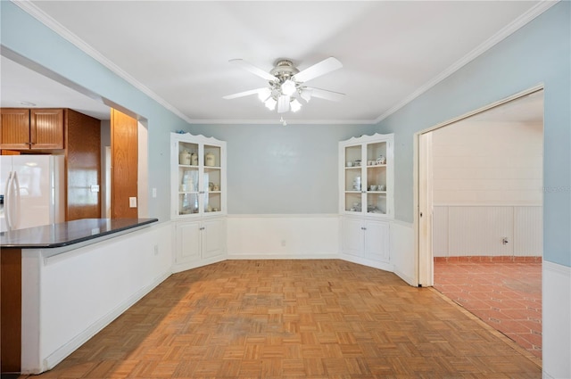 961 Oleander Dr SE, Winter Haven, FL 33880 - unfurnished dining area with ceiling fan, wainscoting, and ornamental molding